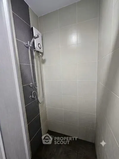 Modern bathroom shower area with sleek tiles and water heater