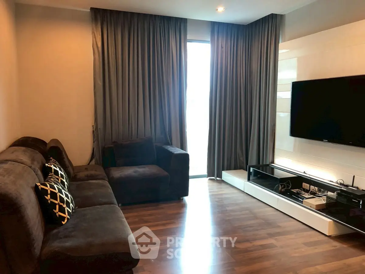 Modern living room with sleek furniture and large TV, perfect for relaxation and entertainment.