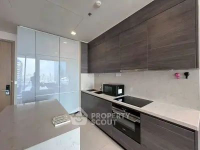 Modern kitchen with sleek cabinetry and built-in appliances in a high-rise apartment.