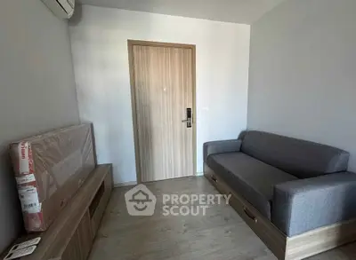 Modern living room with sleek grey sofa and wooden flooring, perfect for cozy urban living.