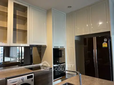 Modern kitchen with sleek cabinetry, built-in oven, and washing machine, perfect for urban living.