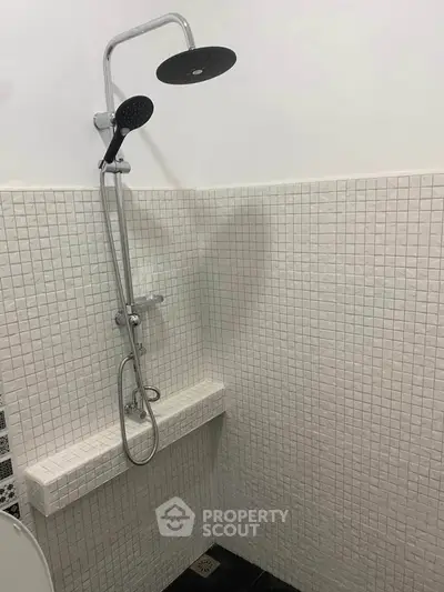 Modern bathroom shower with sleek design and white tiled walls.