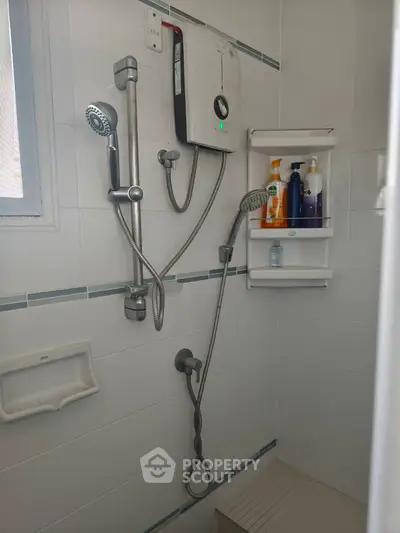 Modern bathroom shower area with sleek fixtures and built-in storage shelves.