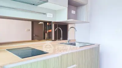 Modern kitchen with sleek countertops and electric stove in contemporary apartment.