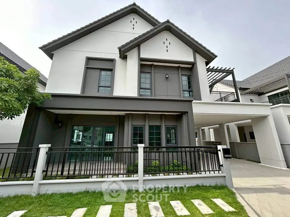 Modern two-story house with spacious balcony and stylish exterior design.