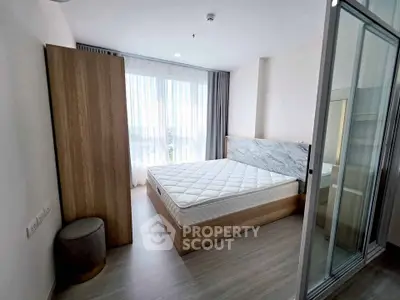 Modern bedroom with large window and minimalist design, featuring a comfortable bed and sleek wooden flooring.