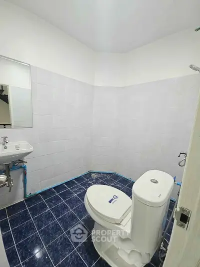 Modern bathroom with blue tiled floor and white fixtures