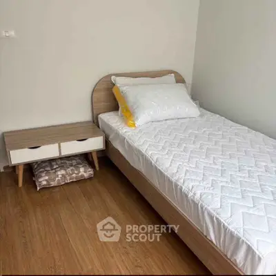 Cozy minimalist bedroom with single bed and wooden flooring, perfect for a serene living space.