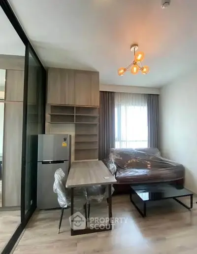 Modern living room with stylish furniture and natural light, featuring a cozy seating area and sleek storage solutions.