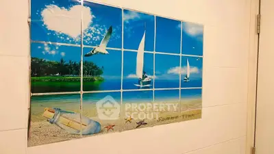 Bathroom wall with beach-themed decorative tiles featuring sailboats and seagulls.