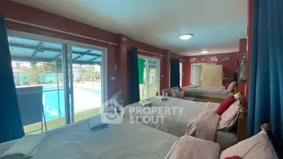 Spacious bedroom with pool view, multiple beds, and modern decor.