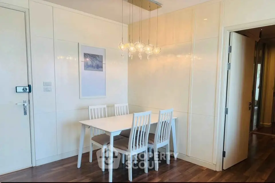 Modern dining area with elegant lighting and minimalist decor in a stylish apartment.