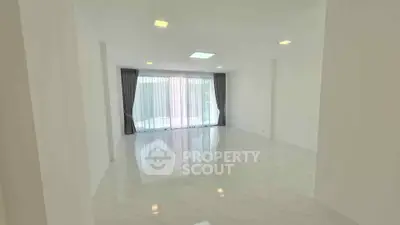 Spacious empty living room with large windows and elegant curtains