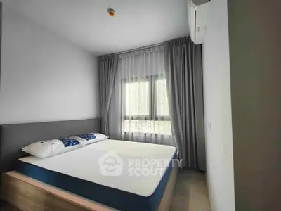 Modern bedroom with large window and stylish curtains in a contemporary apartment.