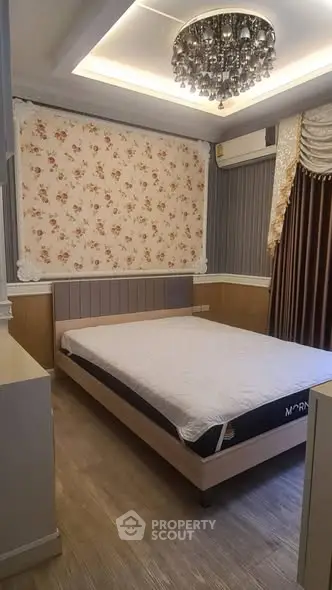 Elegant bedroom with floral wallpaper and chandelier in modern apartment