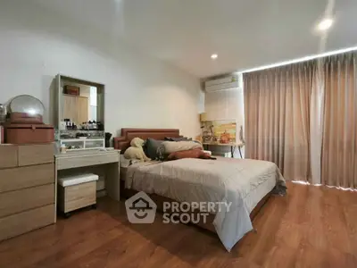 Spacious bedroom with modern decor and wooden flooring