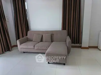 Modern living room with stylish sofa and elegant curtains, perfect for relaxation and comfort.