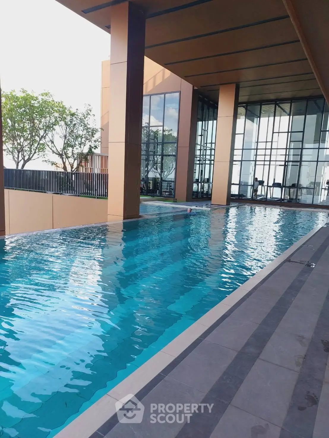 Luxurious modern building with sleek indoor pool and glass facade, perfect for upscale living.