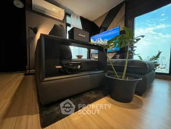 Modern living room with sleek furniture and large window offering stunning city view.