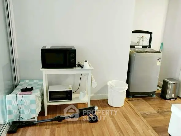 Compact laundry and kitchen area with washing machine and microwave
