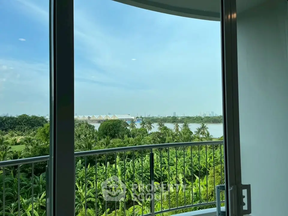 Stunning balcony view overlooking lush greenery and river, perfect for serene living.