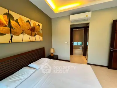 Spacious bedroom with modern decor and ensuite bathroom in luxury apartment.