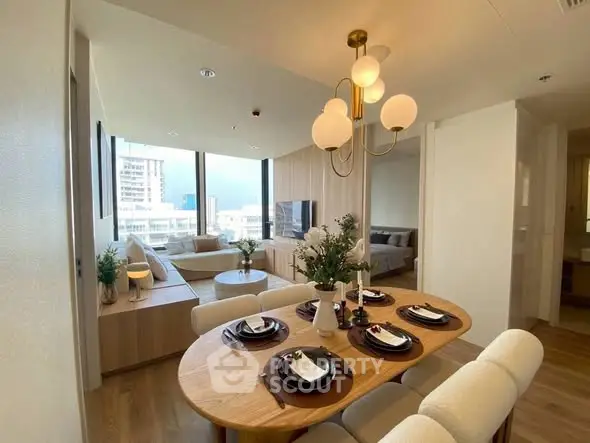 Modern open-plan living and dining area with elegant decor and city view.