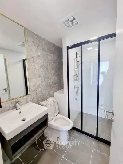 Modern bathroom with sleek shower and elegant fixtures in contemporary apartment.