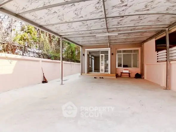 Spacious covered patio with sliding glass doors and ample outdoor space.