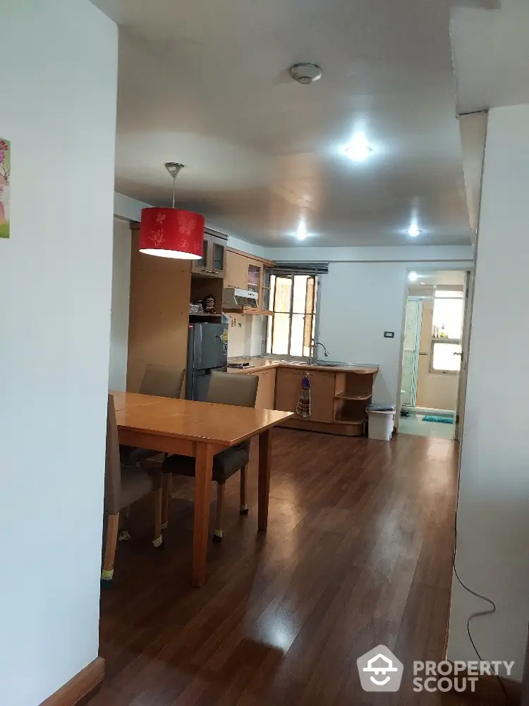 Spacious open-plan kitchen and dining area with wooden flooring and modern lighting.