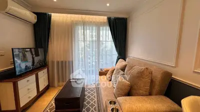 Cozy living room with plush sofa and TV, perfect for relaxation.