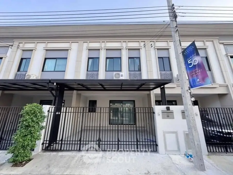 Modern townhouse exterior with gated entrance and sleek design.