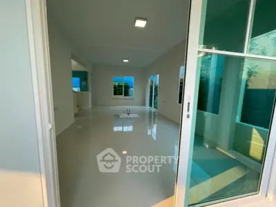 Spacious modern living room with large windows and glossy tiled floors