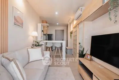 Modern living room with cozy sofa, stylish decor, and open kitchen layout in a contemporary apartment.