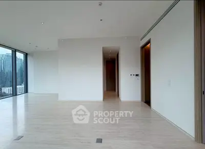 Spacious modern living room with large windows offering stunning city views.