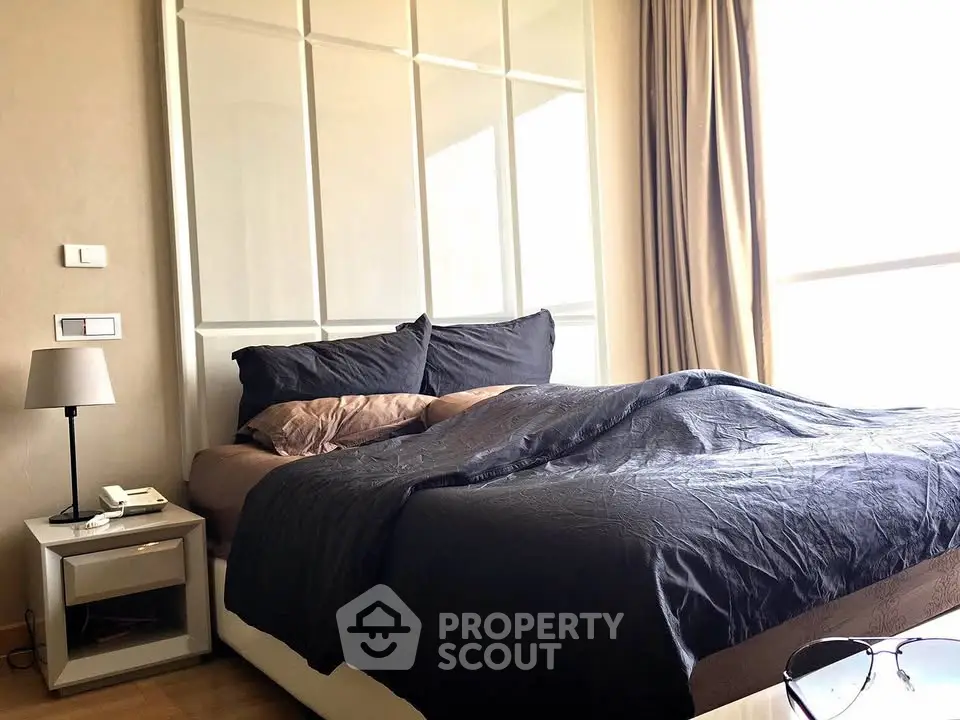 Spacious bedroom with modern decor and large window for natural light.