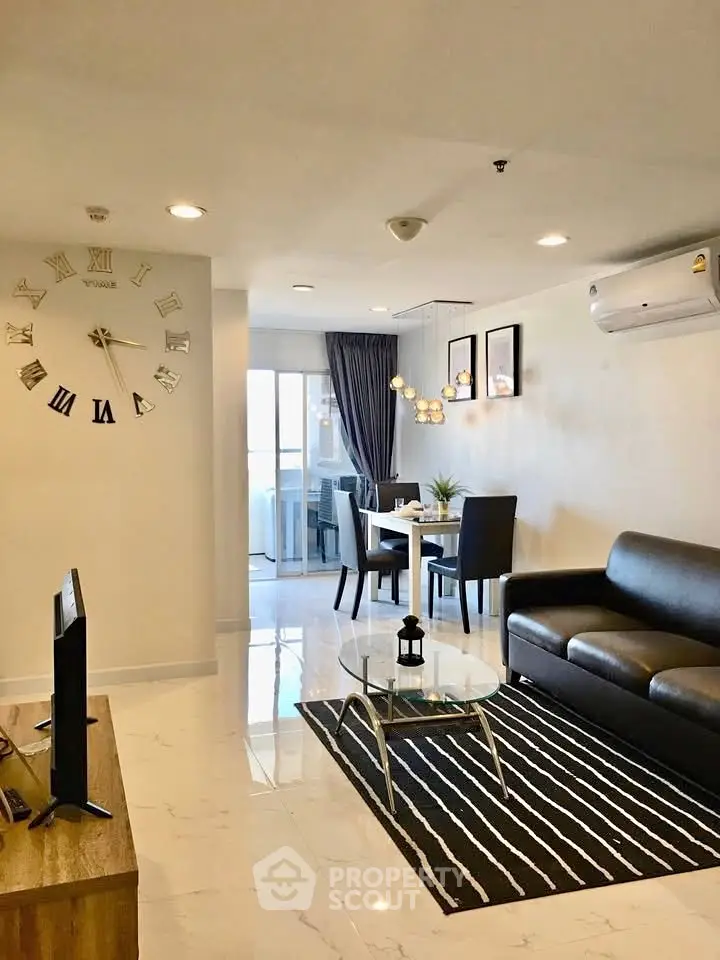Modern living room with stylish decor and dining area in open layout apartment.