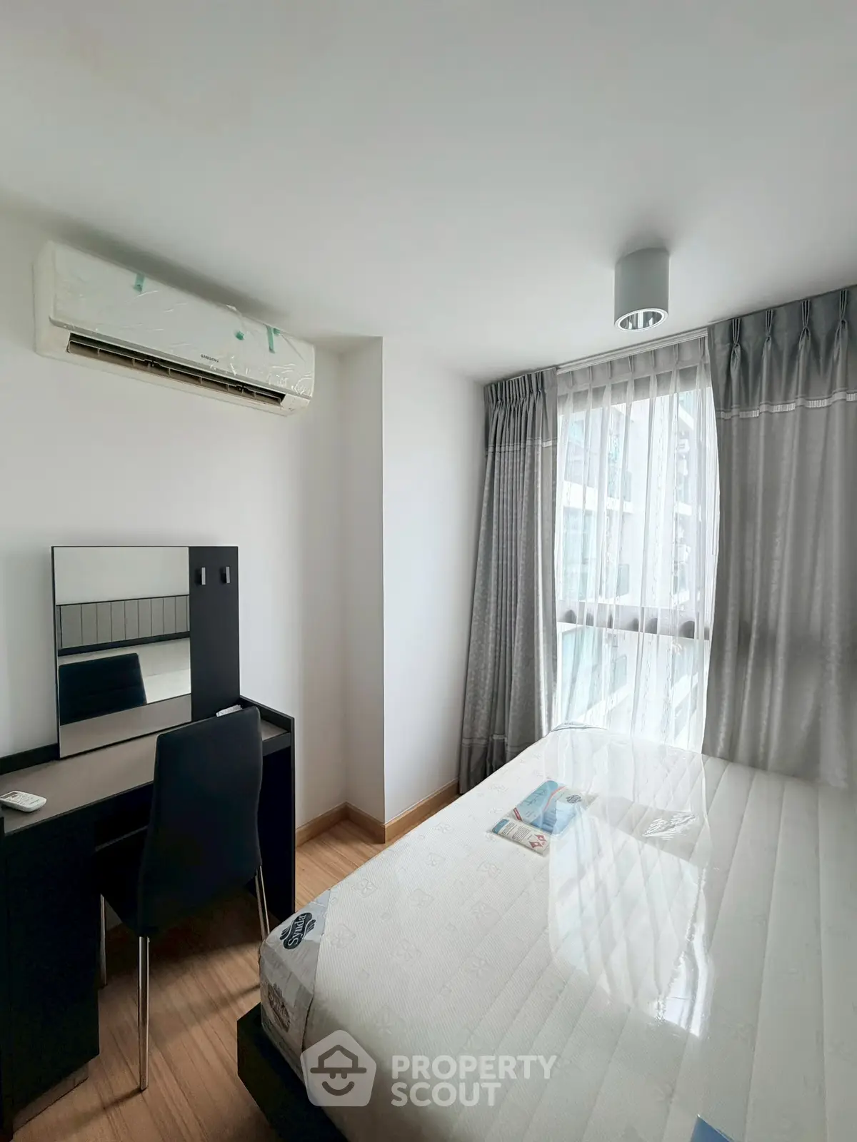Bright and cozy bedroom with modern furnishings and large window for natural light.