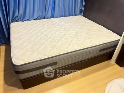 Spacious bedroom with comfortable mattress and elegant blue curtains