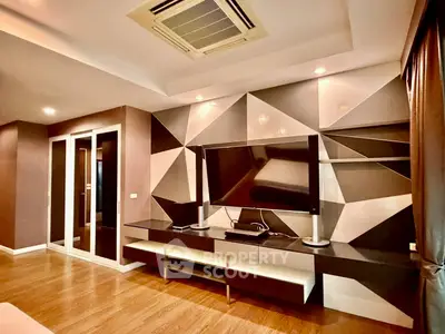 Modern living room with geometric wall design and large TV setup