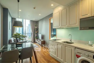 Modern open-plan living room and kitchen with city view, stylish decor, and natural light.