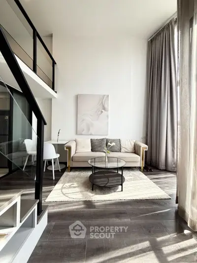 Modern living room with high ceilings, elegant decor, and natural light.