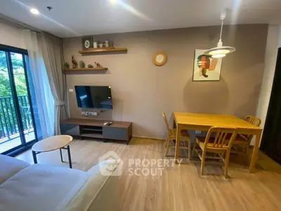 Modern living room with balcony, wooden flooring, and stylish decor in a cozy apartment.