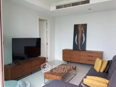 Modern living room with sleek furniture and elephant artwork, featuring a large TV and stylish decor.