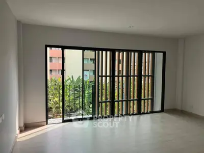 Spacious modern living room with large windows and balcony view