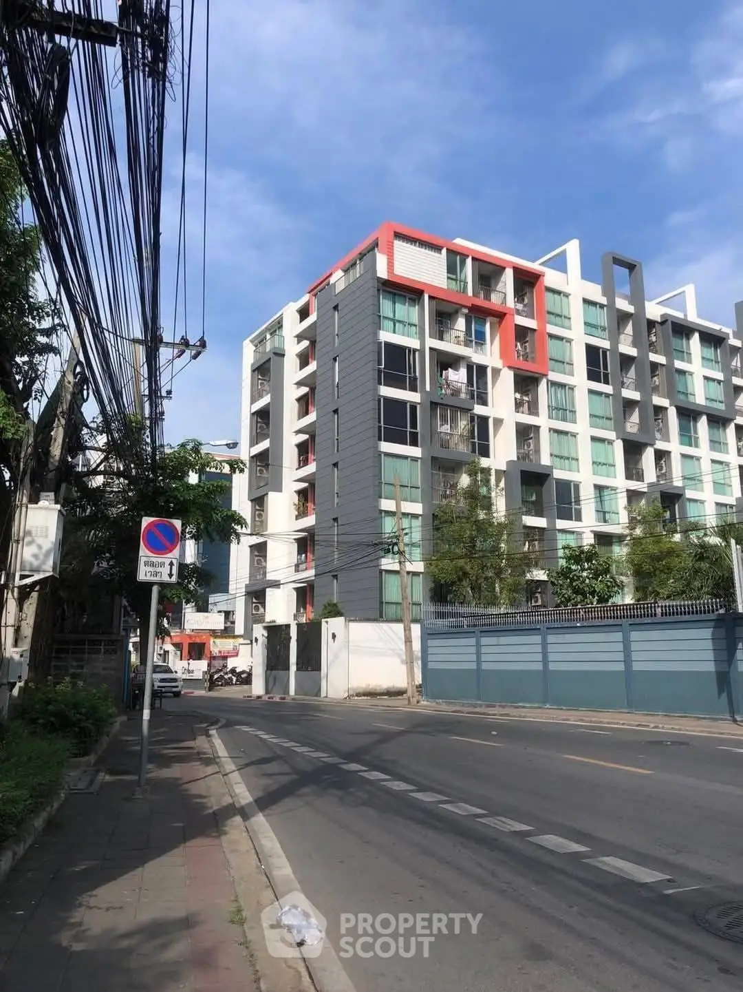 Modern urban apartment building with vibrant facade and street view.