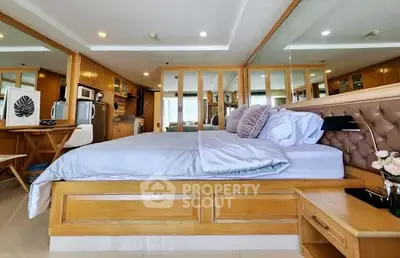 Luxurious bedroom with elegant wooden furnishings and mirrored accents in a modern apartment.