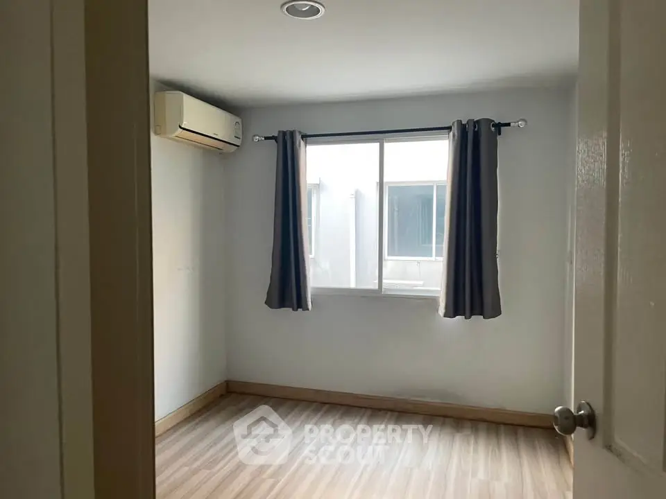 Bright empty bedroom with air conditioning and window view