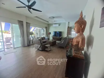 Spacious living room with modern decor and large windows opening to a balcony.