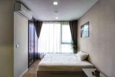 Modern bedroom with large window and minimalist decor in a stylish apartment.